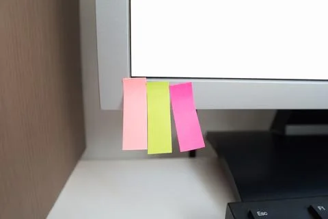 An empty notes template in different colors sticked on a computer monitor Stock Photos