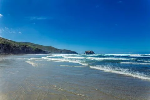 Empty ocean beach with waves in Otago, New Zealand Stock Photos