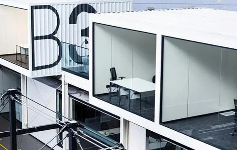 Empty office cubicles with desks and chairs in a modern workspace Stock Photos