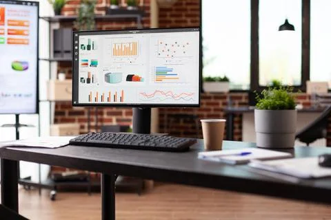 Empty office desk with business data charts on computer Foto stock