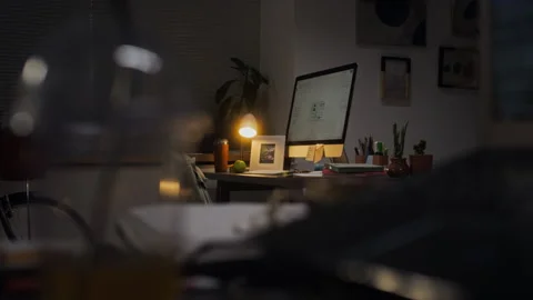 Empty Office Desk with Glowing Computer Representing Overtime Stock Footage 338416675