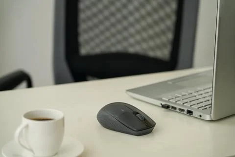 Empty Office Desk With Laptop, Mouse and Coffee Cup Stock Photos