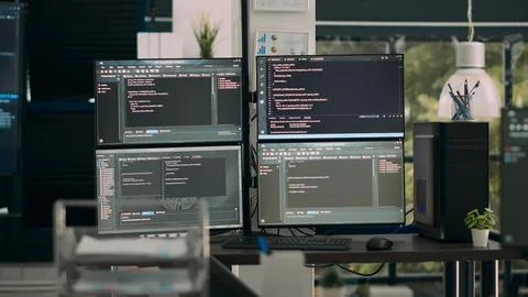 Empty office desk with multiple screens running software developing script 写真素材