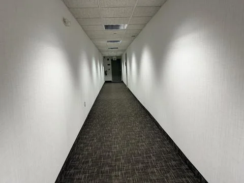 Empty Office Hallway With Patterned Carpet and White Walls Stock Photos