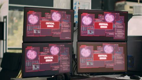 Empty office with multiple monitors showing hacking attack alert Stock Photos