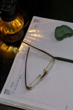 An empty office notebook with pen eye glasses with a lamp shade Stock Photos