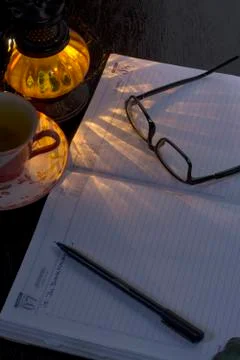 An empty office notebook with pen eye glasses with a lamp shade Stock Photos