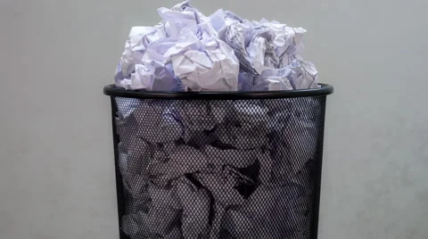 An empty office trash basket gets filled up with waste papers. Stop motion Stock Footage 62491631
