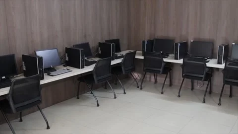 Empty Office Workstations Featuring Black Desktop Computers and Swivel Chairs Stock Footage 334492610