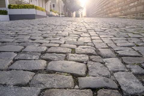 Empty old cobblestone road and sunlight in the morning time Stock Photos