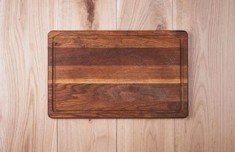 Empty old kitchen cutting board on a wooden table Stock Photos