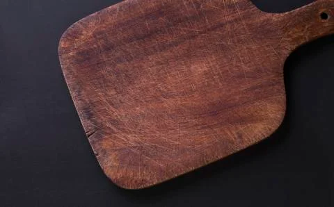 Empty old oak cutting board on a black background Stock Photos