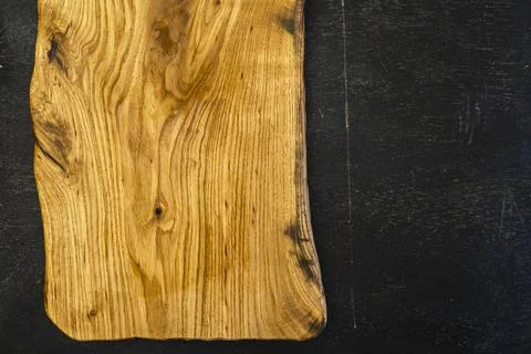 Empty old oak cutting board in rustic style on a dark wooden background. Flat Stock Photos