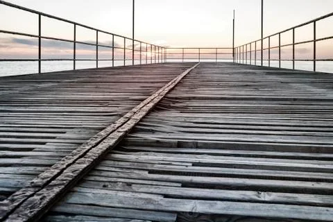 Empty old pier at sunset in the evening on the sea Stock Photos