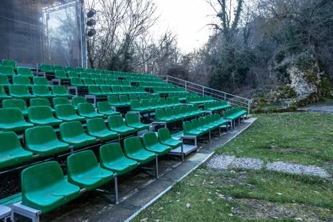 Empty old plastic chairs in the stands of the summer theater. Many empty seat Stock Photos