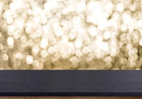 Empty old rustic black wood table top with blur sparkling gold bokeh backgrou Foto stock