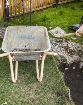 An empty old rusty wheelbarrow for the removal of soil during the constructio Foto stock