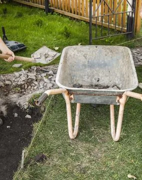 An empty old rusty wheelbarrow for the removal of soil during the constructio Foto stock