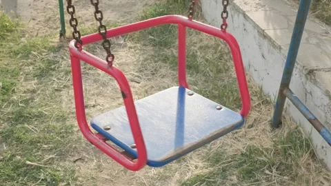 Empty old swing on chains swinging spinning Stock Footage 276106872