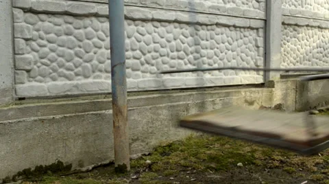 Empty old swings on background concrete fence. Stock Footage 39593106