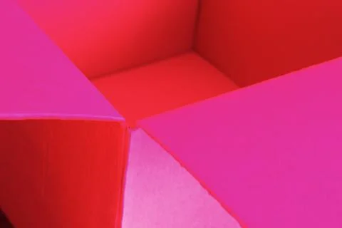 Empty open cardboard box, changed colors, bright background in pastel colors. Stock-Fotos