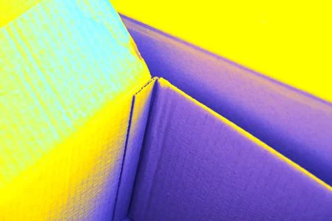 Empty open cardboard box, changed colors, bright background in pastel colors. Stock Photos