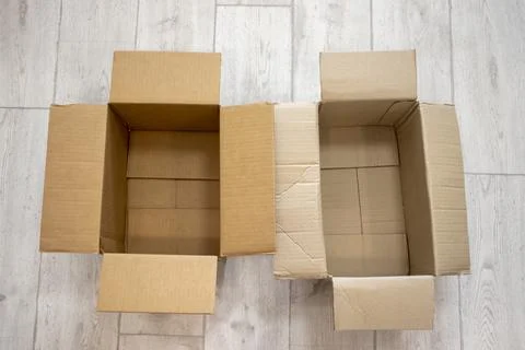 Empty open cardboard boxes against a background of white wood laminate Stock Photos
