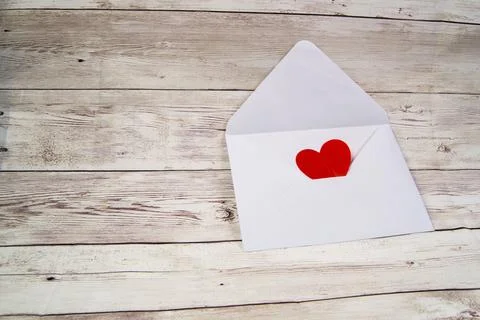 An empty open envelope with a red heart on a wooden background, a copy of the Stock Photos