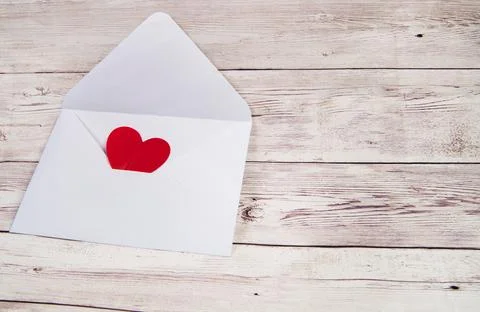 An empty open envelope with a red heart on a wooden background, a copy of the Stock Photos