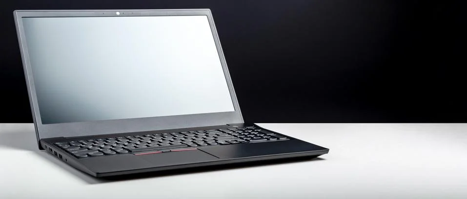 Empty open laptop with mockup on white desk table with black screen. minimalist Stock Photos