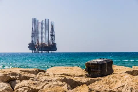 Empty opened gas can in front of oil tower on the sea Stock Photos