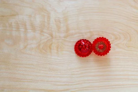 Empty opened red spiked Su Jok massage ball on a wooden background Stock Photos