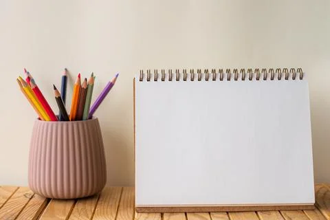 Empty Opened Spiral Notebook Beside Colorful Stack Of Pencils In Container On Stock Photos
