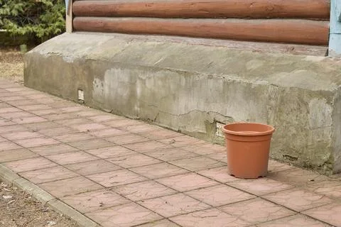 Empty Orange Bucket Next to Weathered Concrete Wall Stock Photos
