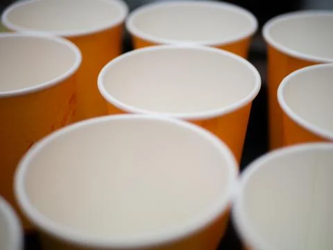 Empty orange paper cups stand in a row Stock Photos