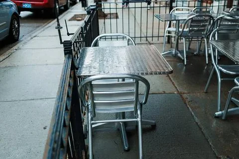 Empty outdoor cafe table with chairs in urban setting Stock Photos