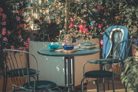 Empty outdoor cafe table surrounded by flowers Foto stock