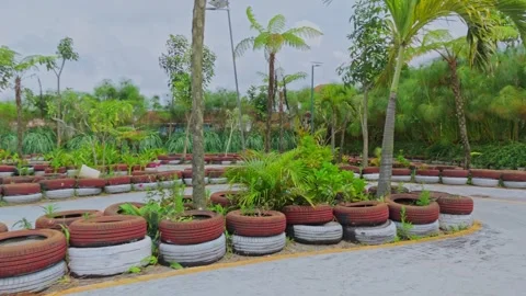 Empty outdoor go-kart track with colorful tire barriers and lush green plants Stock Footage 333778737