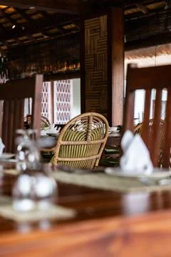 Empty outdoor restaurant dining area with rattan chairs Stock Photos