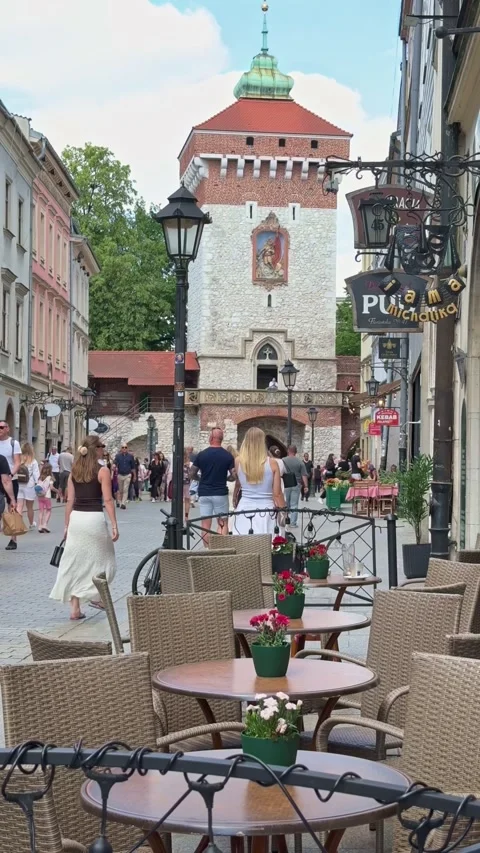 Empty outdoor restaurant seating near the medieval St. Florian's Gate in Krakow Stock Footage 337797085
