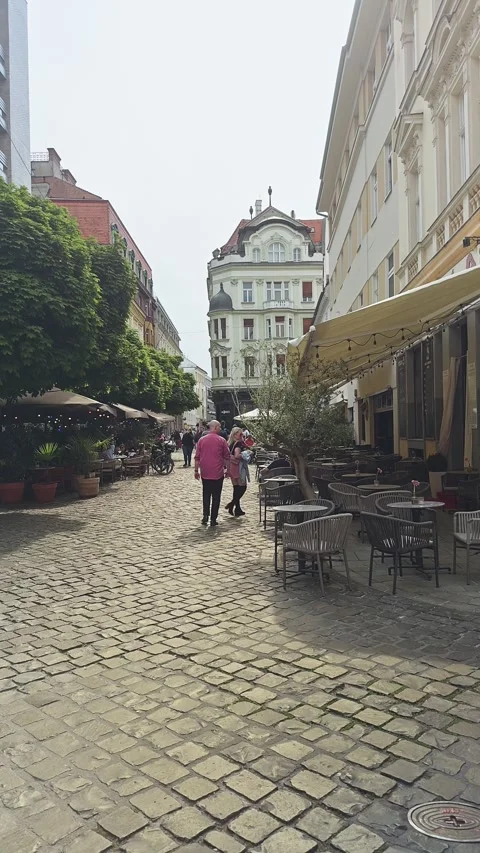 Empty outdoor restaurant tables line the pedestrianised cobblestone streets of Stock Footage 340396622