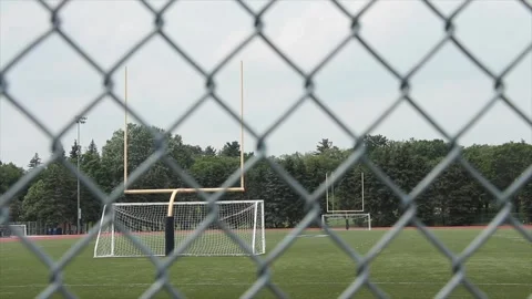 Empty outdoor stadium with soccer nets yellow football goal posts and track Stock Footage 247749027