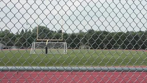 Empty outdoor stadium with soccer nets yellow football goal posts and track Stock Footage 247749037