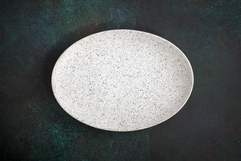 Empty oval plate on dark Fotos de archivo