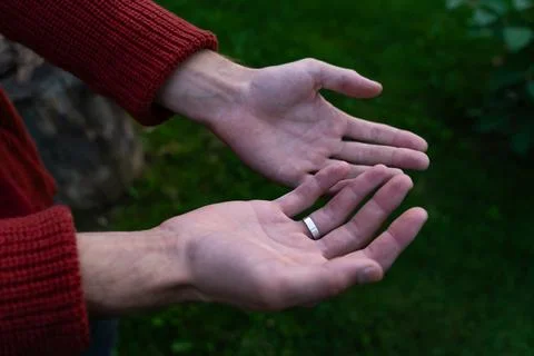 Empty palms of a man up close in a sweater. An engagement ring on her finger Stock Photos