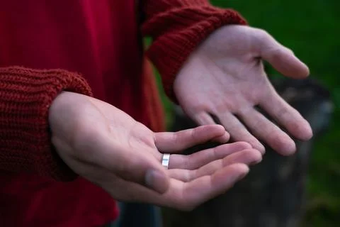 Empty palms of a man up close in a sweater. An engagement ring on her finger Stock Photos