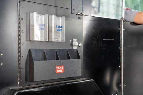 Empty pamphlet holders with take one labels hanging on side of bus Stock Photos