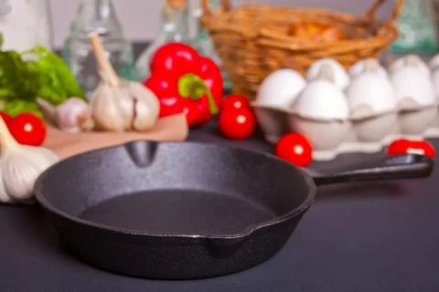 Empty pan with fresh vegetables for cooking on dark table Stock Photos