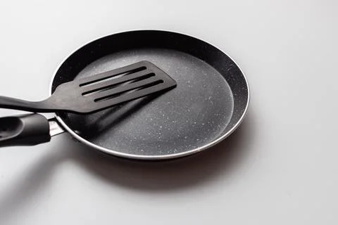 Empty pan on white background. Fried pan with spatula Stock Photos