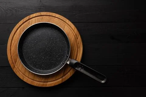 Empty pan on wood board. Empty marble coated iron pot Stock Photos